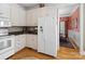 Well-lit kitchen features granite countertops, white cabinetry, stainless steel appliances, and hardwood flooring at 5572 Yorke Nw St, Concord, NC 28027