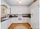Traditional U-shaped kitchen with white cabinetry, granite countertops, and wood flooring at 5572 Yorke Nw St, Concord, NC 28027