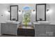 Bright bathroom featuring dual vanity, gray cabinets, black fixtures and arched window at 6800 Augustine Way, Charlotte, NC 28270