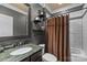 Stylish bathroom with a marble vanity, shower with curtain, and unique shelving at 6800 Augustine Way, Charlotte, NC 28270