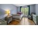 Cozy bedroom featuring a crib, rustic nightstand, reading chair, and a large window at 6800 Augustine Way, Charlotte, NC 28270