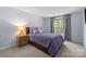 Bedroom featuring a queen bed, nightstand, and natural light from the window at 6800 Augustine Way, Charlotte, NC 28270