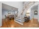 Spacious foyer with hardwood floors flows into the dining room and features a staircase with carpet at 6800 Augustine Way, Charlotte, NC 28270