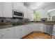 Gourmet kitchen with white cabinetry, stainless steel appliances, and granite countertops, and hardwood floors at 6800 Augustine Way, Charlotte, NC 28270