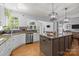 Bright kitchen features white cabinets, a large island, stainless steel appliances, and beautiful granite countertops at 6800 Augustine Way, Charlotte, NC 28270