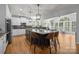 Bright kitchen featuring an island with seating, stainless steel appliances, and large windows for natural light at 6800 Augustine Way, Charlotte, NC 28270