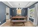 Elegant dining room with dark blue walls, tray ceilings, and modern lighting fixture at 7025 Amberhouse Dr, Charlotte, NC 28212