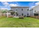 Back exterior of home with large backyard and covered patio at 7025 Amberhouse Dr, Charlotte, NC 28212