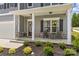 Inviting front porch featuring seating, decorative plants, and stylish stone accents at 7025 Amberhouse Dr, Charlotte, NC 28212