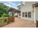 Large back deck area offering serene outdoor living space with a pergola and charming string lights at 7731 Sedgebrook E Dr, Stanley, NC 28164