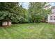 Backyard featuring a lush lawn and fire pit, mature trees, and a storage shed at 7731 Sedgebrook E Dr, Stanley, NC 28164