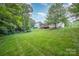 Expansive backyard featuring mature trees and a meticulously manicured lawn at 7731 Sedgebrook E Dr, Stanley, NC 28164