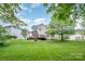 Backyard showing a well-manicured lawn and a deck with a pergola at 7731 Sedgebrook E Dr, Stanley, NC 28164