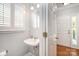 Small powder room features a pedestal sink, a window with shutters, and neutral paint at 7731 Sedgebrook E Dr, Stanley, NC 28164