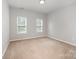 This carpeted bedroom has two windows providing natural light at 7731 Sedgebrook E Dr, Stanley, NC 28164