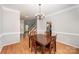 Traditional dining room features a wooden table, chandelier, and access to the entry way and kitchen at 7731 Sedgebrook E Dr, Stanley, NC 28164