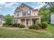 Two-story home featuring a welcoming front porch with classic columns and neat landscaping at 7731 Sedgebrook E Dr, Stanley, NC 28164
