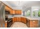 Kitchen showcasing stainless steel appliances, a cooktop, and a view to a living room with lots of natural light at 7731 Sedgebrook E Dr, Stanley, NC 28164