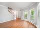 Bright living room featuring hardwood floors, staircase and multiple bright windows at 7731 Sedgebrook E Dr, Stanley, NC 28164