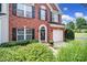 Charming red brick home with black shutters, and a white garage door surrounded by lush green landscaping at 918 Kite Dr, Fort Mill, SC 29715
