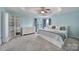 A spacious main bedroom featuring a tray ceiling, plush carpeting, built-in shelving, and a large window at 918 Kite Dr, Fort Mill, SC 29715