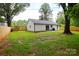 Spacious backyard featuring a new fence, lush green grass, and mature trees at 9208 Detroiter Dr, Huntersville, NC 28078