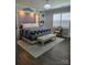 Cozy main bedroom featuring a decorative wall panel, hardwood floors, and a sitting area at 1224 Dali Blvd, Mount Holly, NC 28120