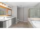 Primary bathroom showcasing a double vanity, soaker tub, and walk-in shower at 12325 Woodside Falls Rd, Pineville, NC 28134