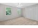 Cozy bedroom with neutral carpet, a ceiling fan, and double door closet at 12325 Woodside Falls Rd, Pineville, NC 28134