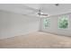 Spacious carpeted bedroom featuring a ceiling fan and bright windows at 12325 Woodside Falls Rd, Pineville, NC 28134