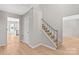 Bright foyer featuring wood flooring, stairs, and neutral paint at 12325 Woodside Falls Rd, Pineville, NC 28134