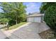 Attached two-car garage with large driveway and mature trees in a serene setting at 12325 Woodside Falls Rd, Pineville, NC 28134