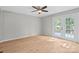 Bright living room features wood floors, a ceiling fan, and white-trimmed glass doors for indoor/outdoor living at 12325 Woodside Falls Rd, Pineville, NC 28134