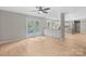 Open-concept living area with hardwood flooring, ceiling fan, and views of the eat-in kitchen at 12325 Woodside Falls Rd, Pineville, NC 28134
