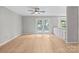 Bright living room features wood floors, a ceiling fan, and white-trimmed glass doors for indoor/outdoor living at 12325 Woodside Falls Rd, Pineville, NC 28134