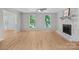 Bright living room features hardwood flooring, a brick fireplace, and natural lighting at 12325 Woodside Falls Rd, Pineville, NC 28134
