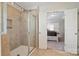 Modern tiled bathroom with a glass shower and a doorway to the bedroom at 12704 Franklin Square Rd, Charlotte, NC 28213