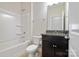 Clean bathroom with a shower-tub combo, a modern vanity with granite countertop, and neutral-colored tiling at 12704 Franklin Square Rd, Charlotte, NC 28213