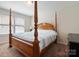 Bedroom showcasing a wooden canopy bed, carpeted floors, and a window view at 12704 Franklin Square Rd, Charlotte, NC 28213