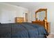 Bedroom with light wood furniture, dark bedding, and multiple closet doors for ample storage at 12704 Franklin Square Rd, Charlotte, NC 28213