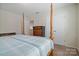Bedroom featuring a wooden canopy bed, carpet, and double door closet at 12704 Franklin Square Rd, Charlotte, NC 28213