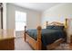 Bedroom with light wood furniture, dark bedding, a window with blinds, and neutral colored walls at 12704 Franklin Square Rd, Charlotte, NC 28213
