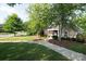 A charming clubhouse nestled among mature trees with manicured landscaping and a welcoming sidewalk entrance at 12704 Franklin Square Rd, Charlotte, NC 28213