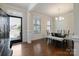 Bright dining room with hardwood floors, white trim, glass table, chandelier, and a view through the front door at 12704 Franklin Square Rd, Charlotte, NC 28213