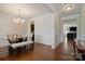 Dining room with dark hardwood floors, light walls, a glass table, and a view through the doorway to other rooms at 12704 Franklin Square Rd, Charlotte, NC 28213