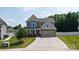 Two-story home with a two-car garage, beautiful lawn, manicured landscaping, and a long concrete driveway at 12704 Franklin Square Rd, Charlotte, NC 28213