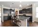 Modern kitchen with stainless steel appliances, dark cabinets, granite countertops and a central island with seating at 12704 Franklin Square Rd, Charlotte, NC 28213