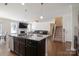 Open floorplan kitchen with dark cabinets, granite countertops, stainless appliances, and an island at 12704 Franklin Square Rd, Charlotte, NC 28213