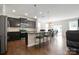 Open concept kitchen with dark cabinets, stainless steel appliances, island with seating, and adjacent dining area at 12704 Franklin Square Rd, Charlotte, NC 28213