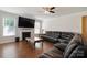 Comfortable living room with a fireplace, large windows, hardwood floors, and a sectional leather couch at 12704 Franklin Square Rd, Charlotte, NC 28213